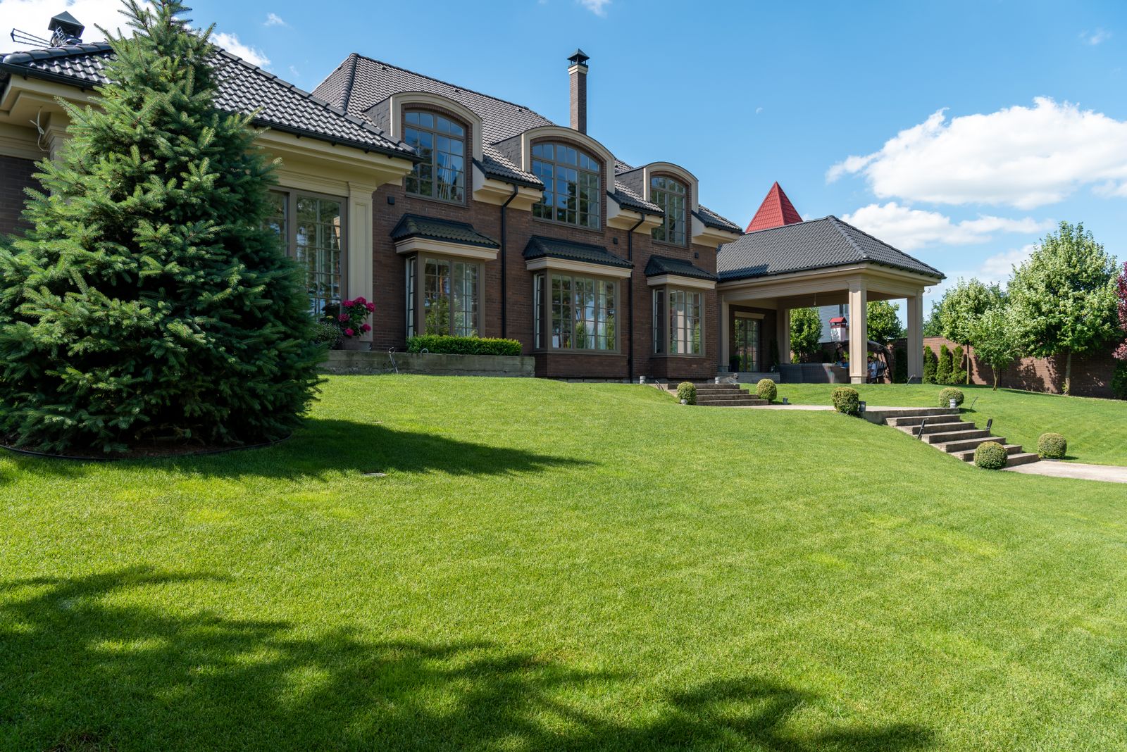 A large, immaculate lawn in front of a country house